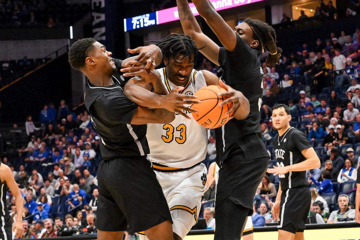 Missouri Tigers center Josh Gray (33) fights through Mississippi State Bulldogs forward KeShawn Murphy (3) and guard Riley Kugel (2) during the first half at Bridgestone Arena in Nashville on March 13, 2025.