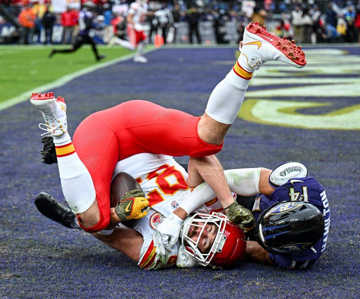 Travis Kelce comes down with a touchdown catch in front of Baltimore Ravens safety Kyle Hamilton on Jan. 28, 2024, during the AFC Championship Game in Baltimore.