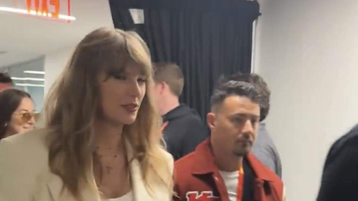 Taylor Swift wore light colors in her Super Bowl ensemble Sunday. But her bodyguard rocked a Chiefs jacket.