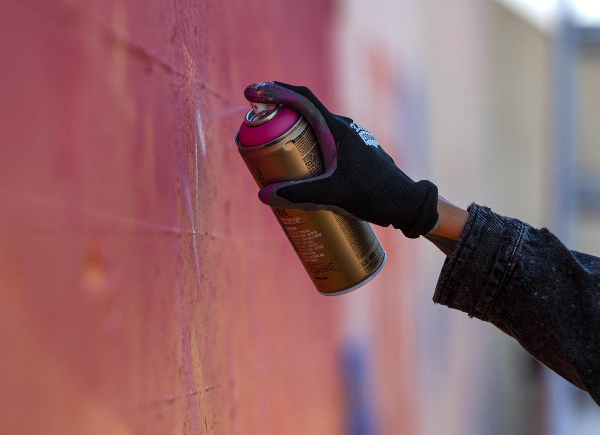 Emily Ding spray paints the outline of a swallow bird on her mural on Friday, Sept. 15, 2023, at the Riverfront Heritage Trail in Kansas City. The Port KC project was initiated after they had spent tens of thousands of dollars preventing vandalism along the river front trail.