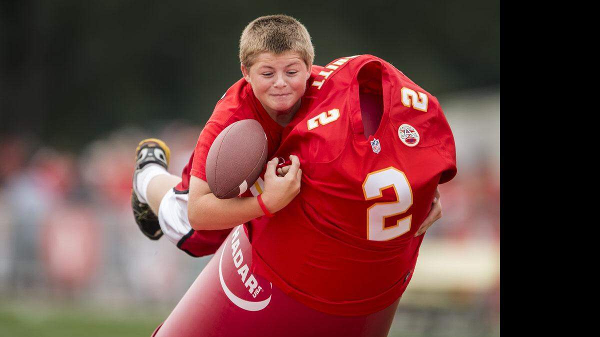 Nicholas Gill, 12, of Glenwood, Iowa, leveled a tackling dummy but fumbled on a skills course during Family Fun Day on Saturday morning during the Chiefs summer training camp at Missouri Western State University in St. Joseph.
