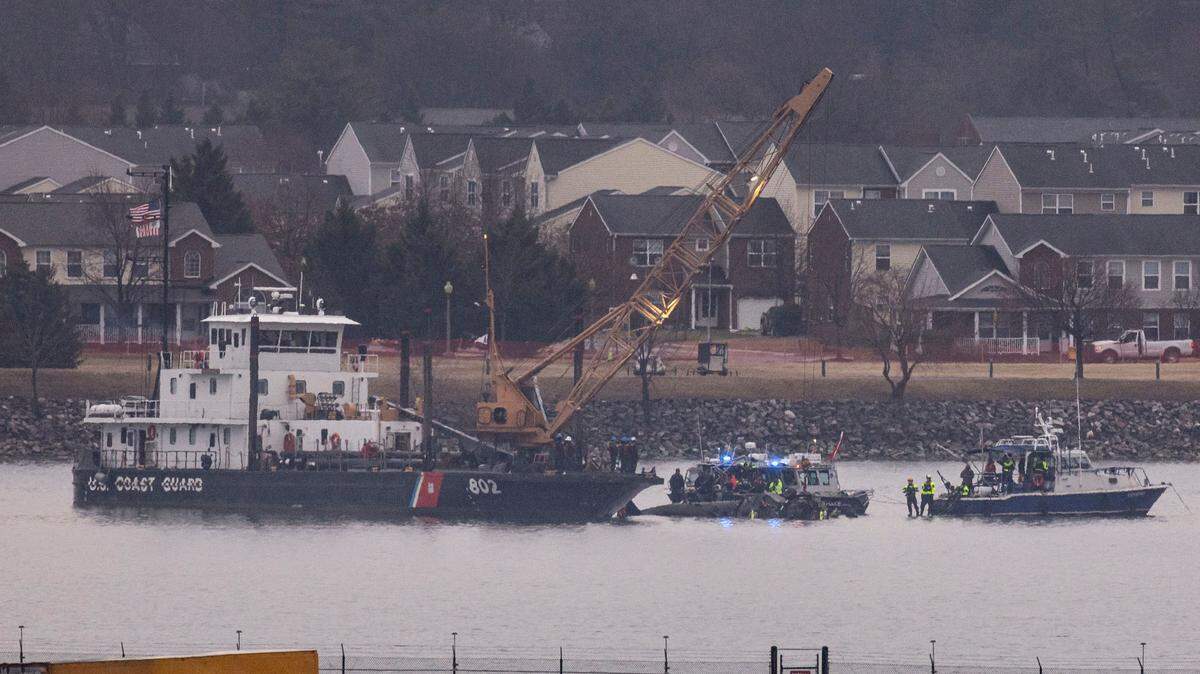 A Coast Guard crane arrives to remove the wreckage of a military Black Hawk helicopter after the crash of an American Airlines plane on the Potomac River as it approached the airport on Jan. 31, 2025, in Arlington, Virginia. The American Airlines flight from Wichita, Kansas collided midair with a military Black Hawk helicopter while on approach to Ronald Reagan Washington National Airport. According to reports, there were no survivors among the 67 people on both aircraft. (Al Drago/Getty Images/TNS)