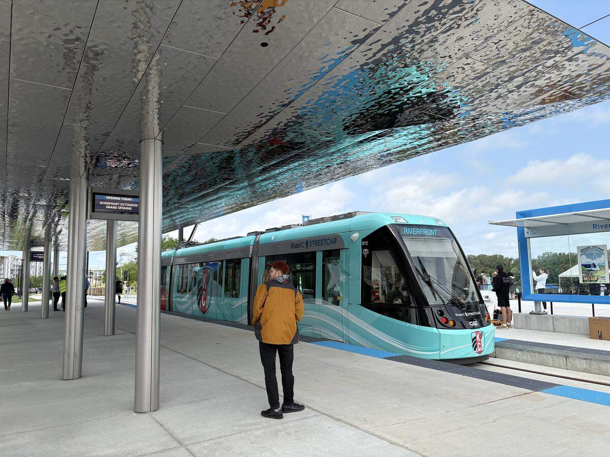 A photographer stands in front of the Kansas City Streetcar at the new CPKC Pavilion at the Riverfront streetcar extension grand opening. May 18, 2026.