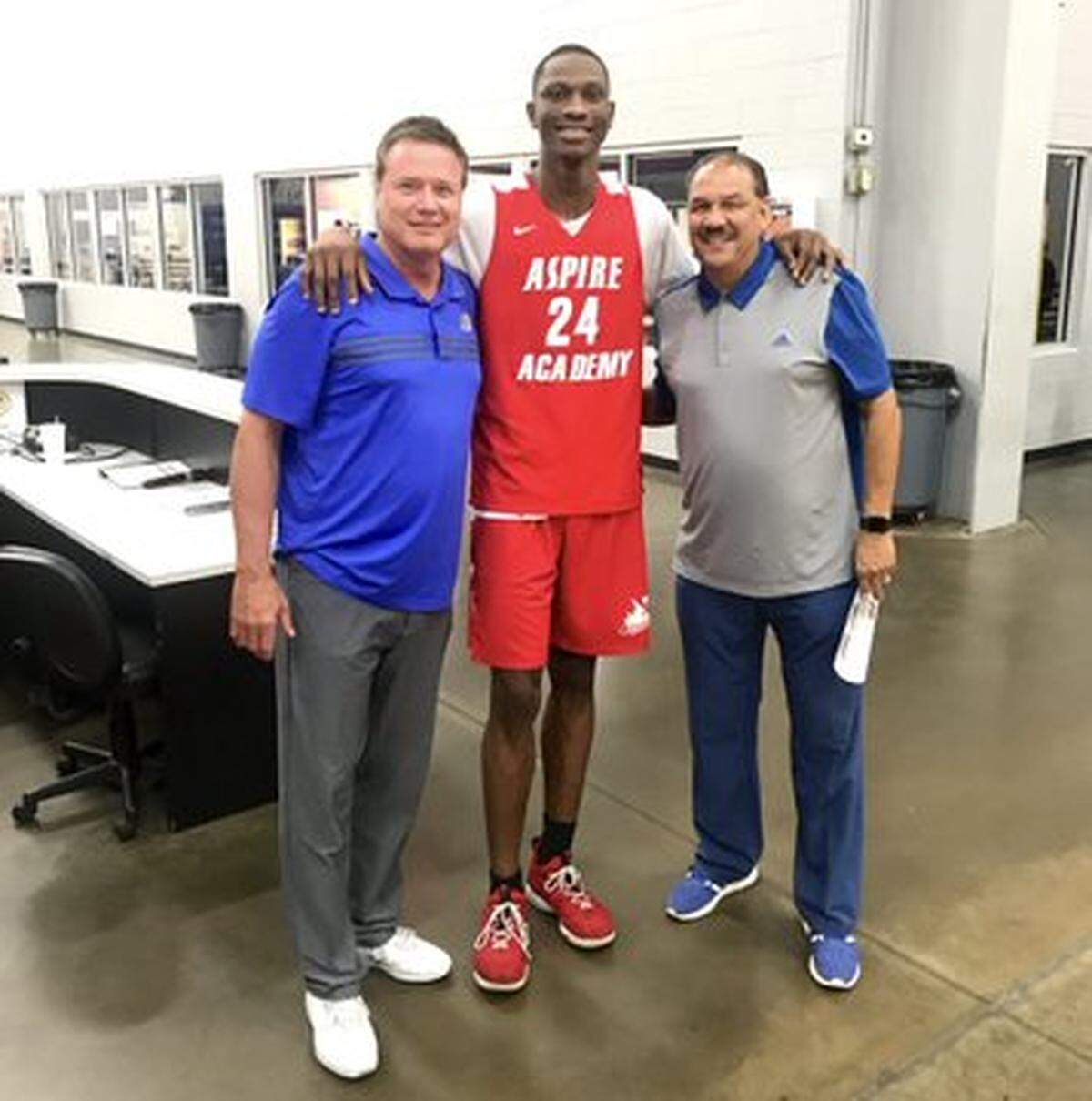 Gethro Muscadin, center, poses for a photo with Kansas coach Bill Self and assistant Kurtis Townsend.