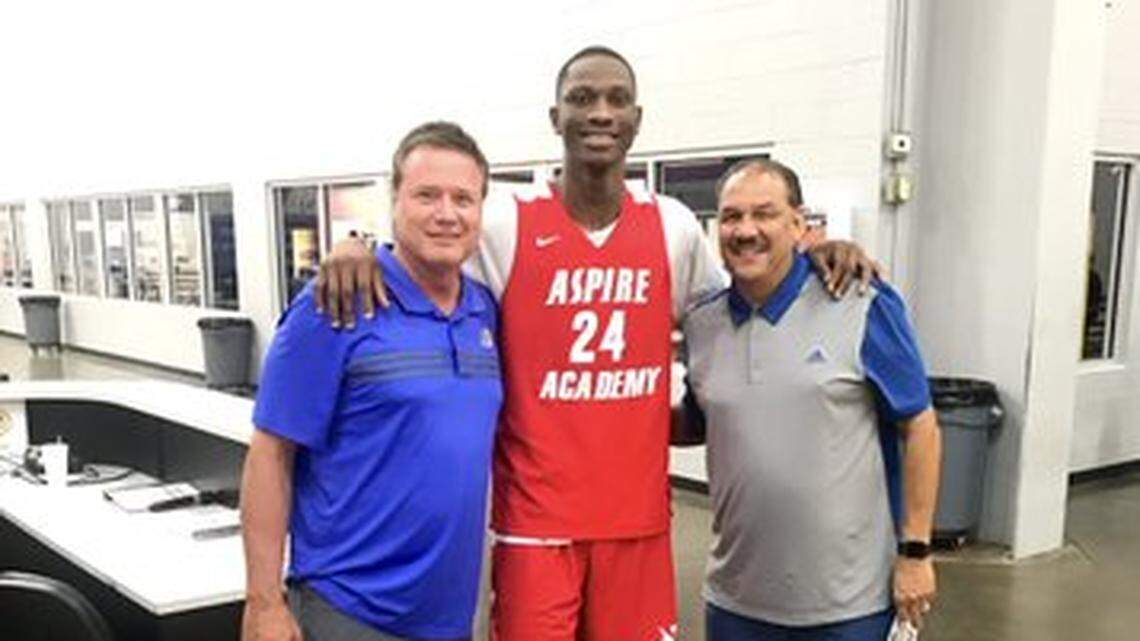 Gethro Muscadin, center, poses for a photo with Kansas coach Bill Self and assistant Kurtis Townsend.