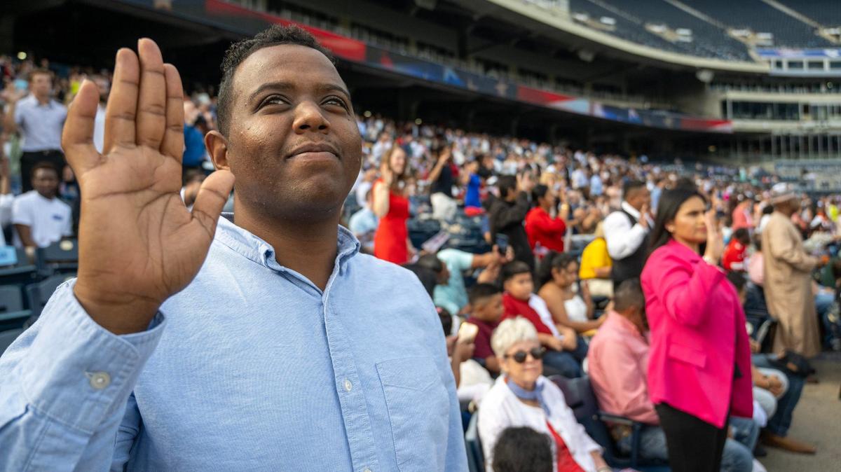 Ahmed Mohamedsalih, a native of Sudan, takes the Oath of Allegiance with more than 600 other individuals from 95 countries who became U.S. citizens during a naturalization ceremony at Kauffman Stadium in Kansas City on Thursday, Sept. 12, 2024.