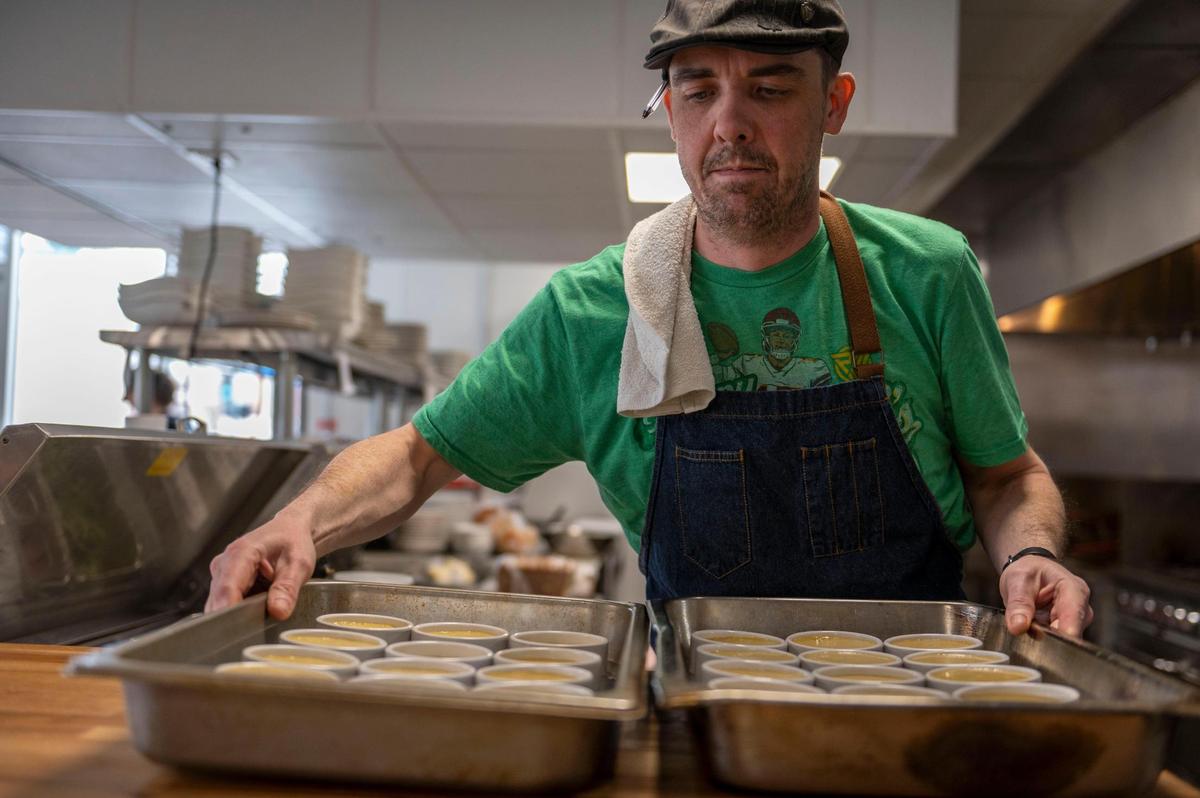 Shaun Brady, chef and co-owner of Brady and Fox, prepares to put creme brúlées in a fridge at Brady & Fox in March 2022, shortly after he opened the restaurant with his business partner, Graham Farris.