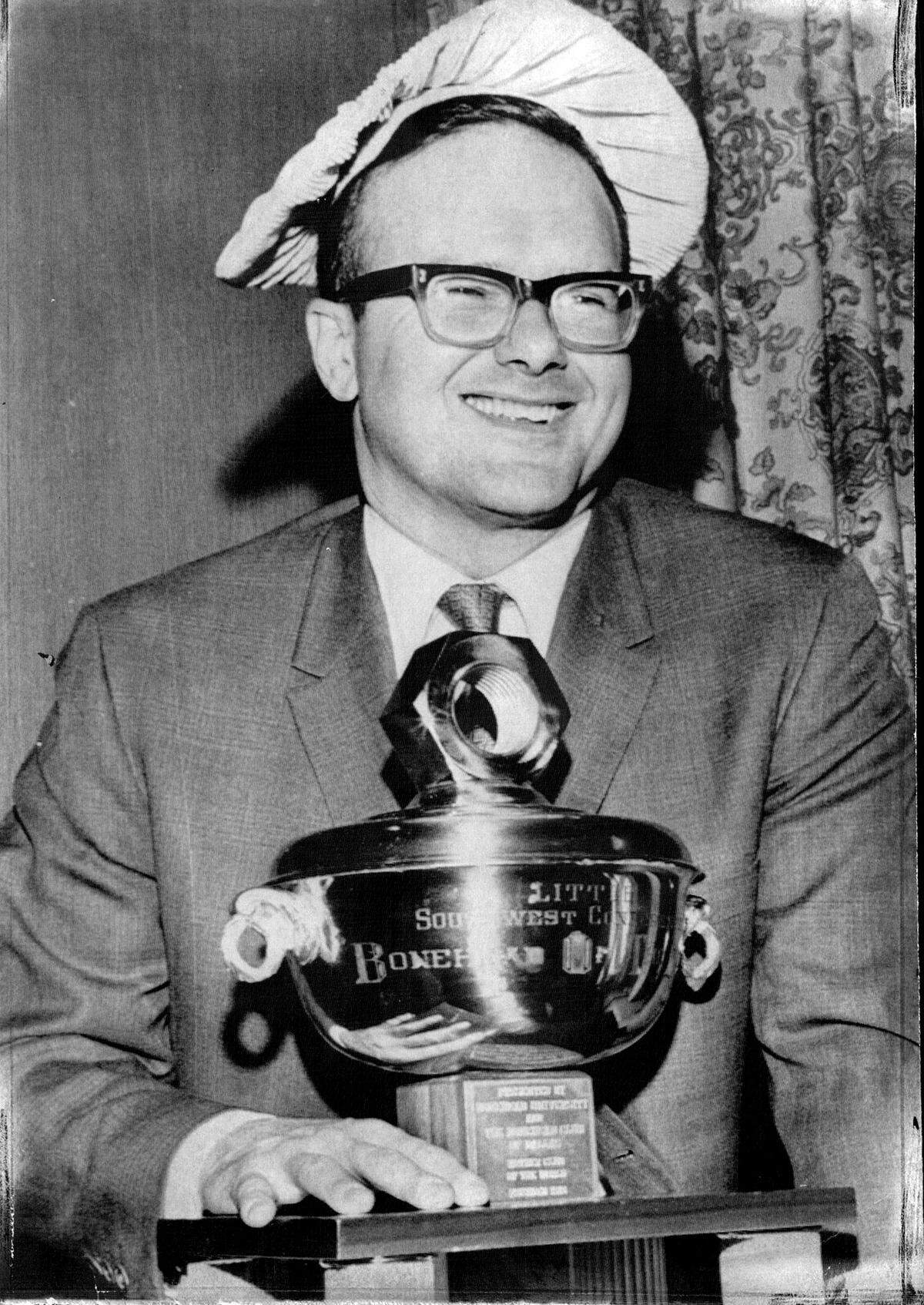 Lamar Hunt, founder of the American Football League and owner of the Kansas City Chiefs, Super Bowl champions, received the “Bonehead Trophy of the Year” award in Dallas in 1970. The award was humorously presented to the now-defunct AFL. by the Dallas Bonehead Club, poking fun at the league for paying the NFL $18 million for what was jokingly referred to as the “dubious privilege” of joining a group of so-called losers.