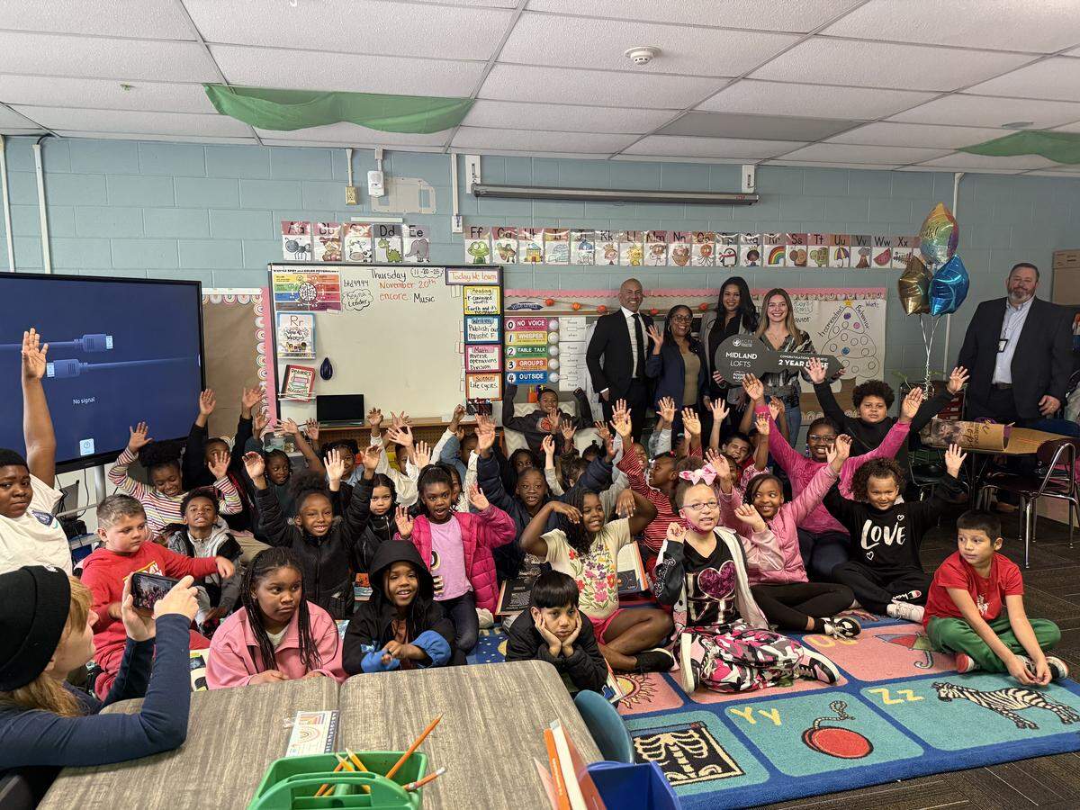 Brooke Wurtz (right, holding key) taking pictures with her classroom after she won a free two-year lease from a giveaway between Kansas City Public Schools and the Kansas City Power & Light District on Nov. 20 at Faxon Elementary.