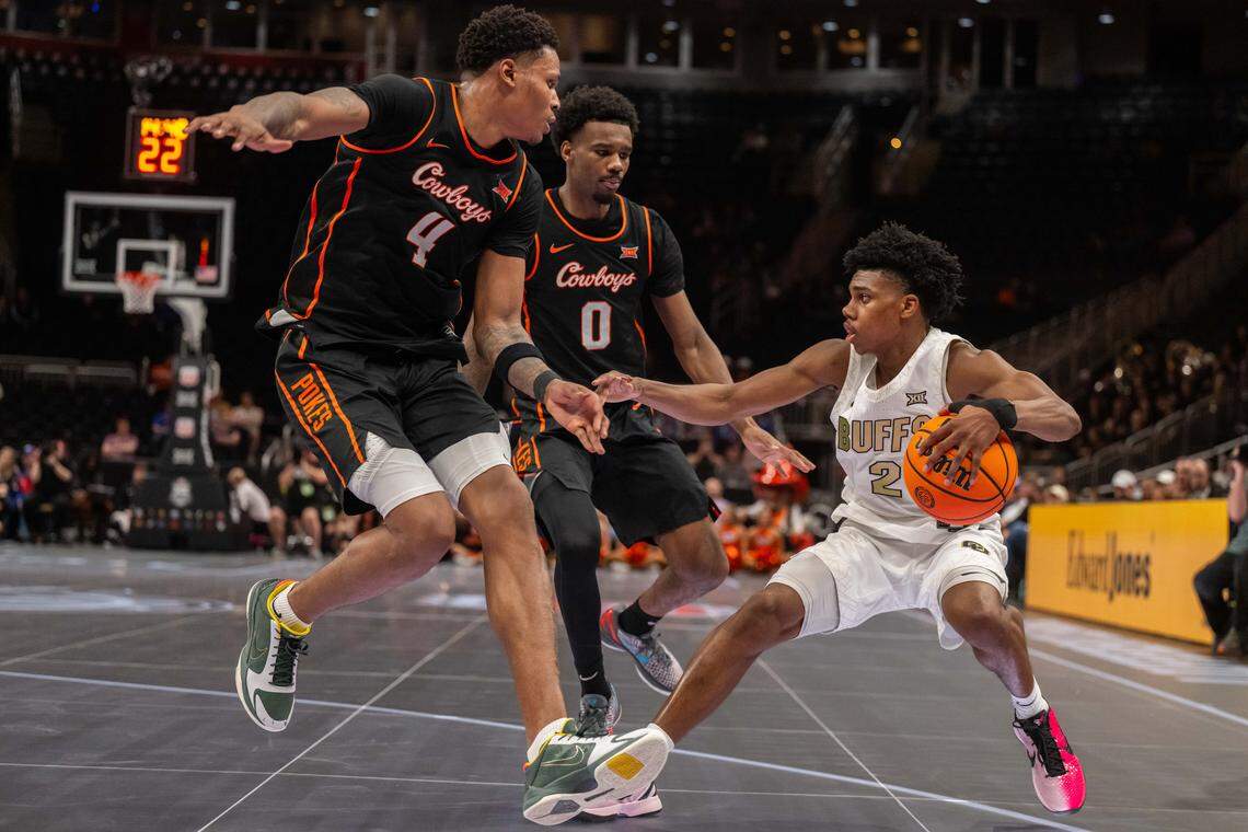 Colorado Buffaloes guard Isaiah Johnson (2) stumbles as he is double teamed by two Oklahoma State Cowboys defenders in the second half of the Colorado Buffaloes first round game vs. the Oklahoma State Cowboys in the Big 12 Men's Basketball Tournament, on Tuesday, March 10, 2026, at T-Mobile Center.