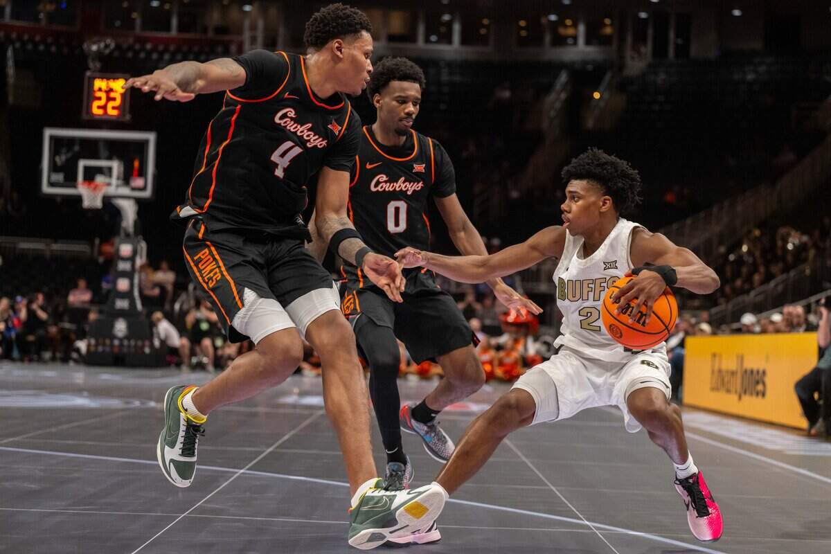 Colorado Buffaloes guard Isaiah Johnson (2) stumbles as he is double teamed by two Oklahoma State Cowboys defenders in the second half of the Colorado Buffaloes first round game vs. the Oklahoma State Cowboys in the Big 12 Men's Basketball Tournament, on Tuesday, March 10, 2026, at T-Mobile Center.
