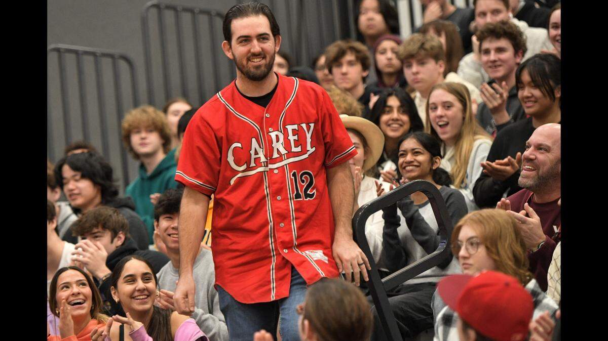 Blue Valley West teacher Alex Lahasky stands up at a school assembly after finding out he won the Milken Educator Award.