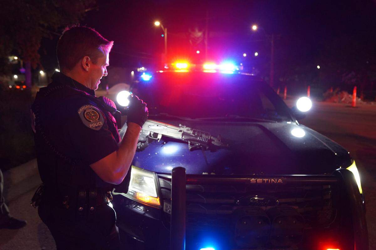 A KCPD officer is seen with a firearm seized from a suspect during an enforcement push against illegal street activity over Memorial Day weekend Friday.