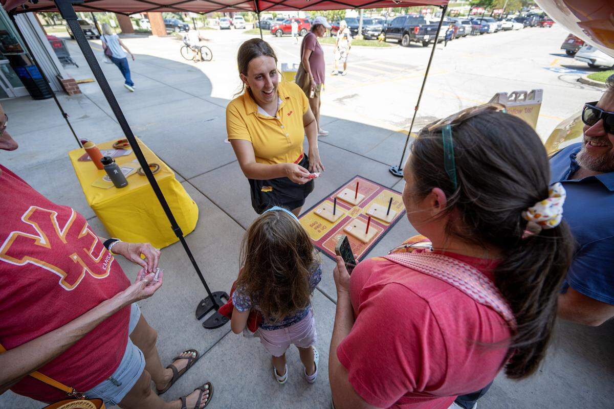 Oscar Mayer Hotdogger Reana Sinclair, known as RelishRaena, hands out whistles to visitors during the Wienermobile's stop at a local Hy-Vee on Friday, Aug. 8, 2025, in Lee's Summit.
