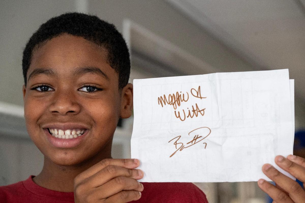 Langston Blount, 11, displays his math paper which was autographed by Kansas City Royals shortstop Bobby Witt Jr. and his wife, Maggie, during to Crossroads Academy on Wednesday, May 7, 2025. Witt Jr. spoke with the fifth-grade class about reading and answered questions as part of the Royals Literacy League’s efforts to encourage reading among Kansas City elementary students.