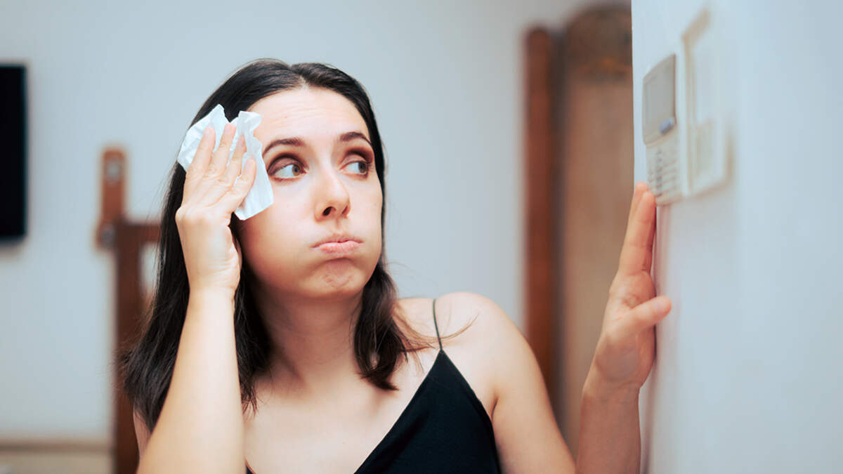 Woman Feeling Hot During Summer Setting Her Thermostat temperature air conditioning ac furnace air conditioner climate control climate change global warming weather