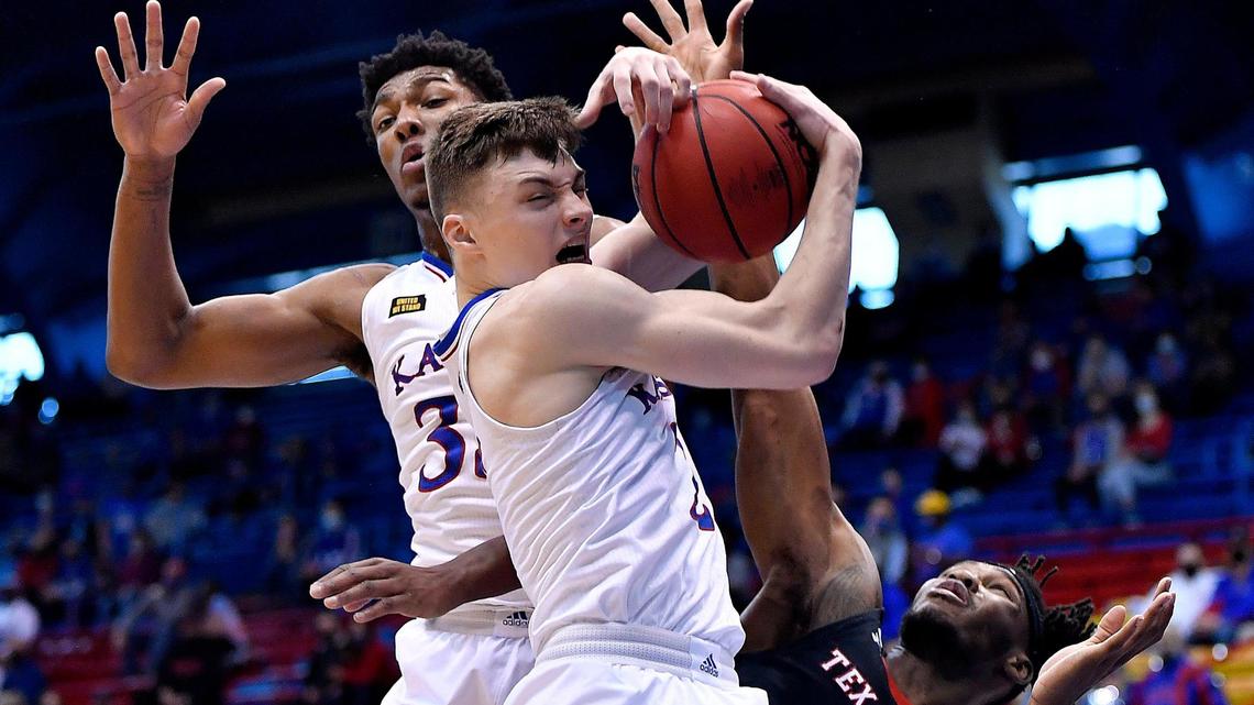 KU’s Christian Braun rips down a rebound in front of teammate David McCormack and Texas Tech’s Tyreek Smith during the first half of Saturday’s Big 12 Conference game at Allen Fieldhouse.