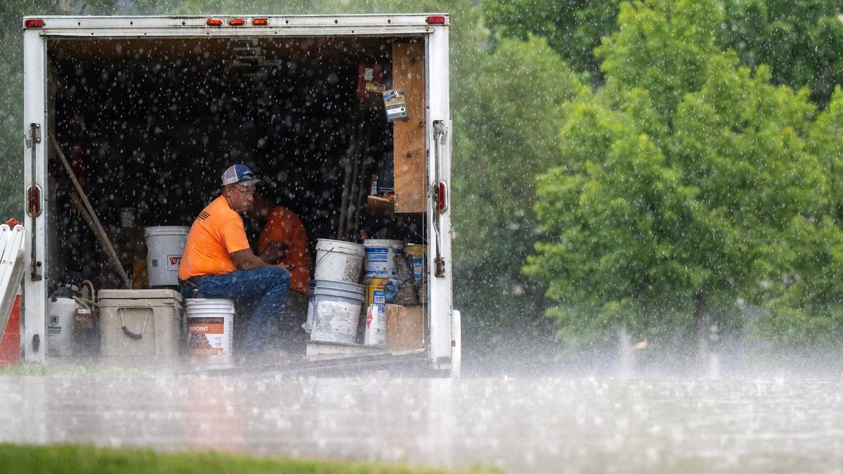 A construction worker watches the rain fall from inside their truck at the National WWI Museum and Memorial on Tuesday, July 16, 2024, in Kansas City.
