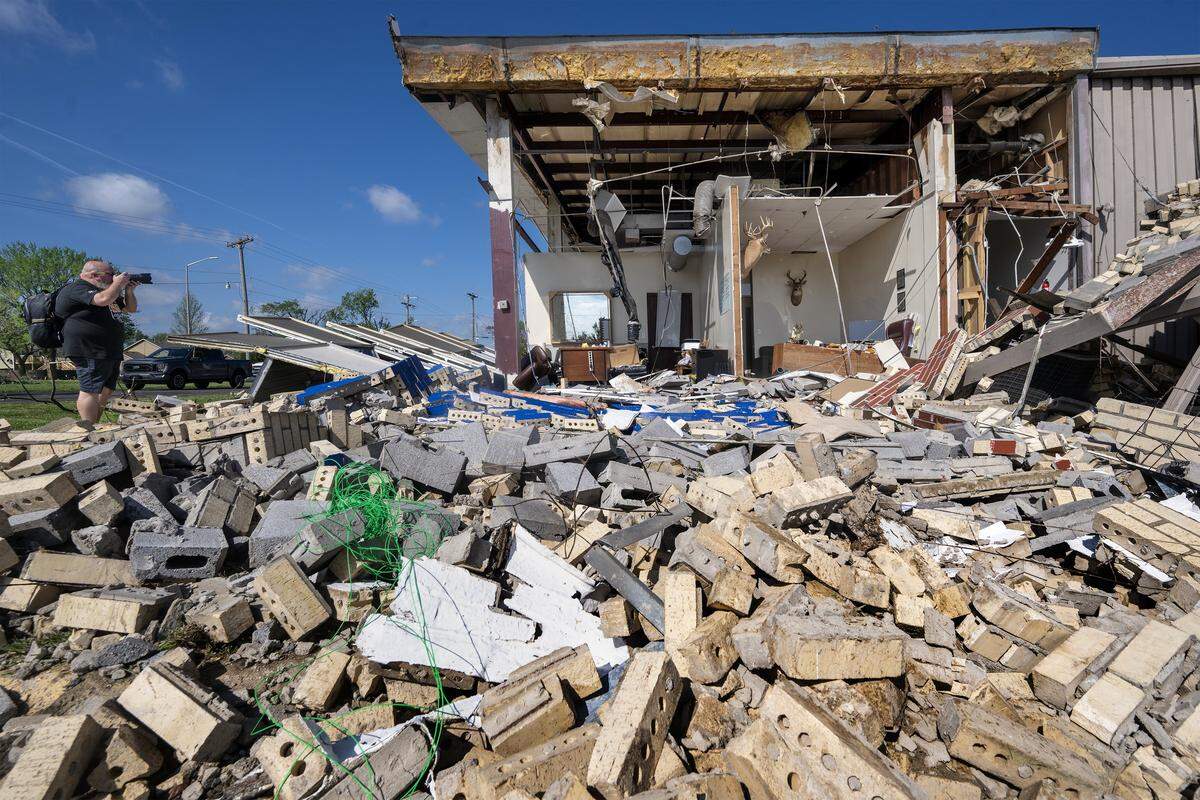 A man captures photos of the TruComp Pipe manufacturing plant in Ottawa, Kansas, on Tuesday, April 14, 2026. A tornado struck the 221 W. 17th St. facility on Monday night, causing such extensive damage that city officials have since deemed the building unsafe for entry.