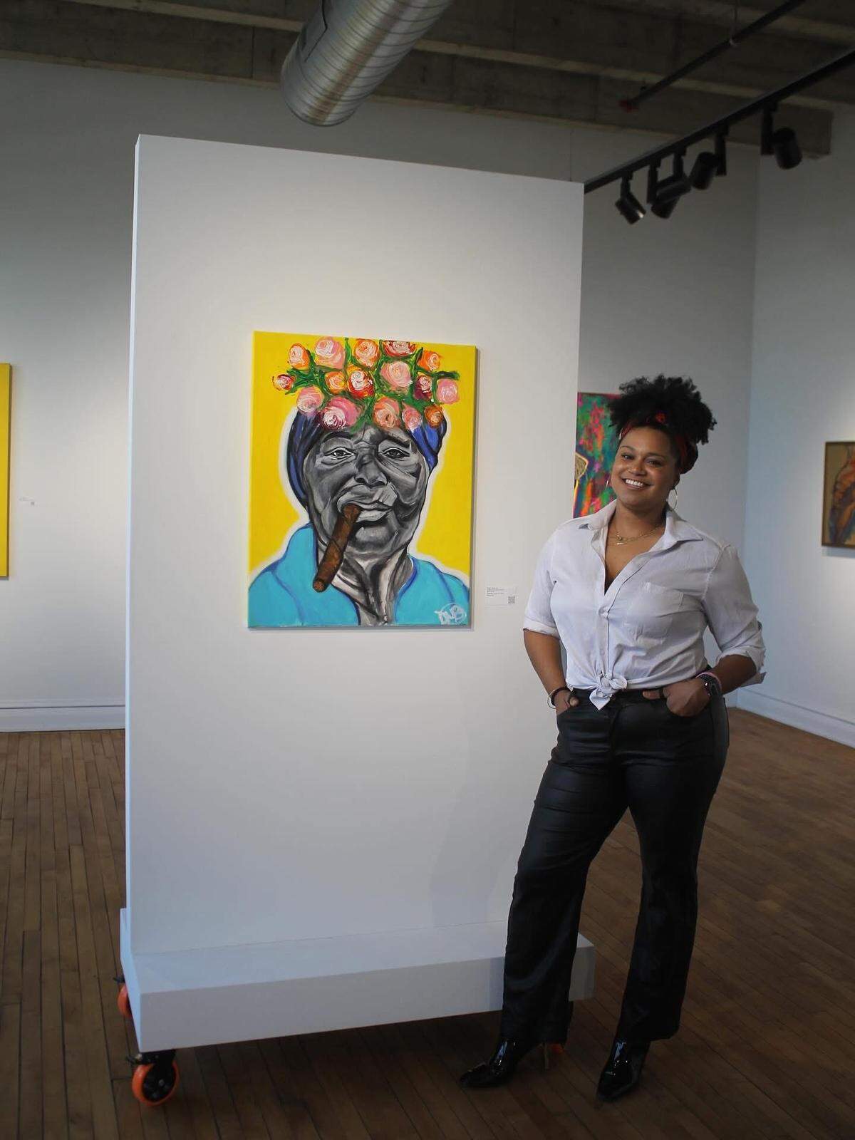 Daisha Maria-Breona poses with her painting titled Celebración, apart of the Reclaiming the Canvas event held at the Zhou B Art Center KC.