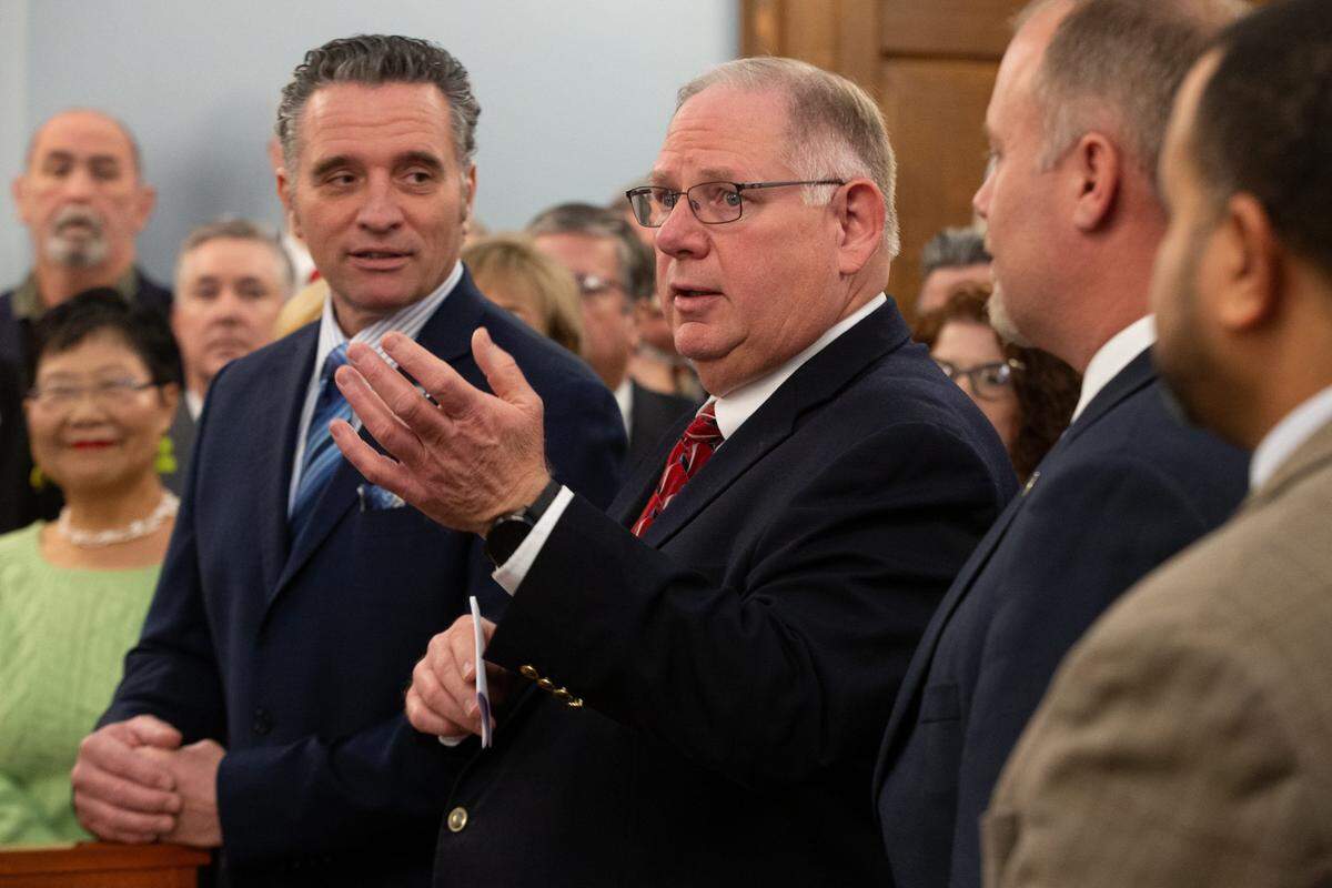 Kansas House Speaker Rep. Dan Hawkins, center, speaks as Kansas Senate President Ty Masterson, left, looks on.