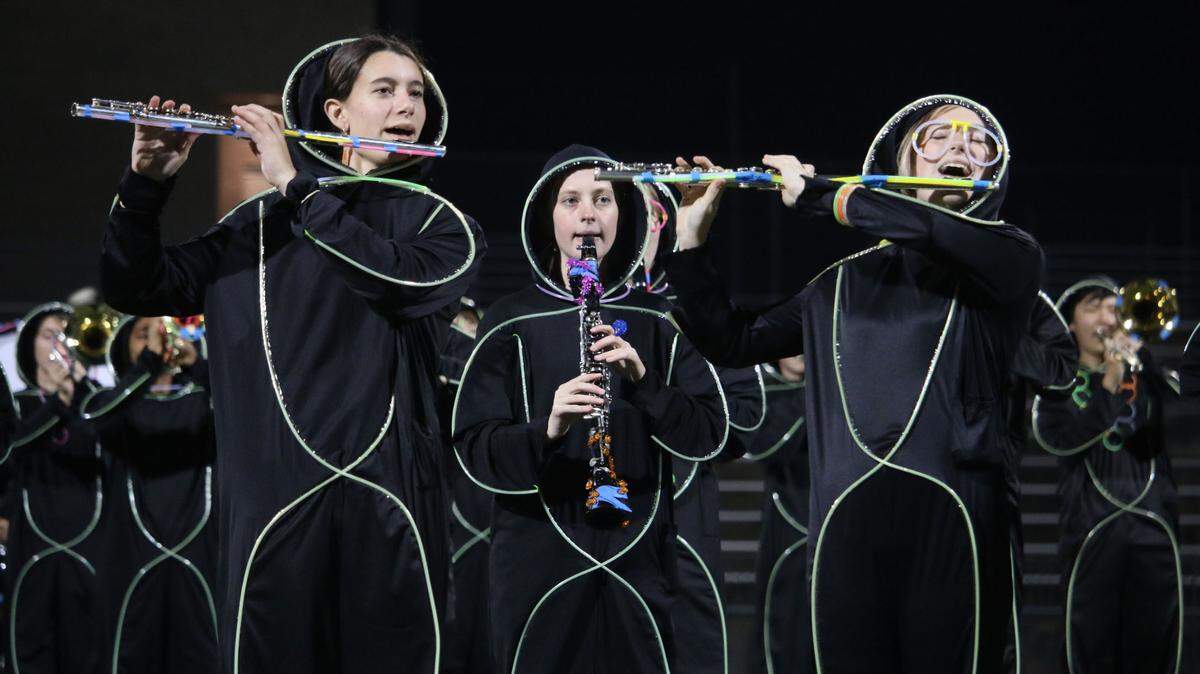 Riley Saugstad, Bailey Kinkelaar and Lizzie Herron play as part of Blue Valley Northwest’s marching band before the lights went out at Glow Show.