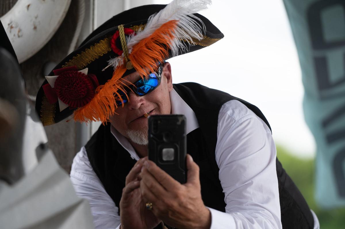 Roger Macbride photographs the Riverbeat Rascals jazz band onboard his boat, the Kansas City Lady, Saturday during the Kawsmouth River Carnival.
