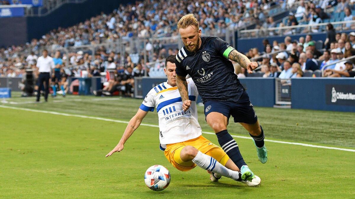 Sporting Kansas City forward Johnny Russell, right, beats the San Jose Earthquakes’ Nathan Cardoso to the ball during a scoreless first half at Children’s Mercy Park Wednesday night.