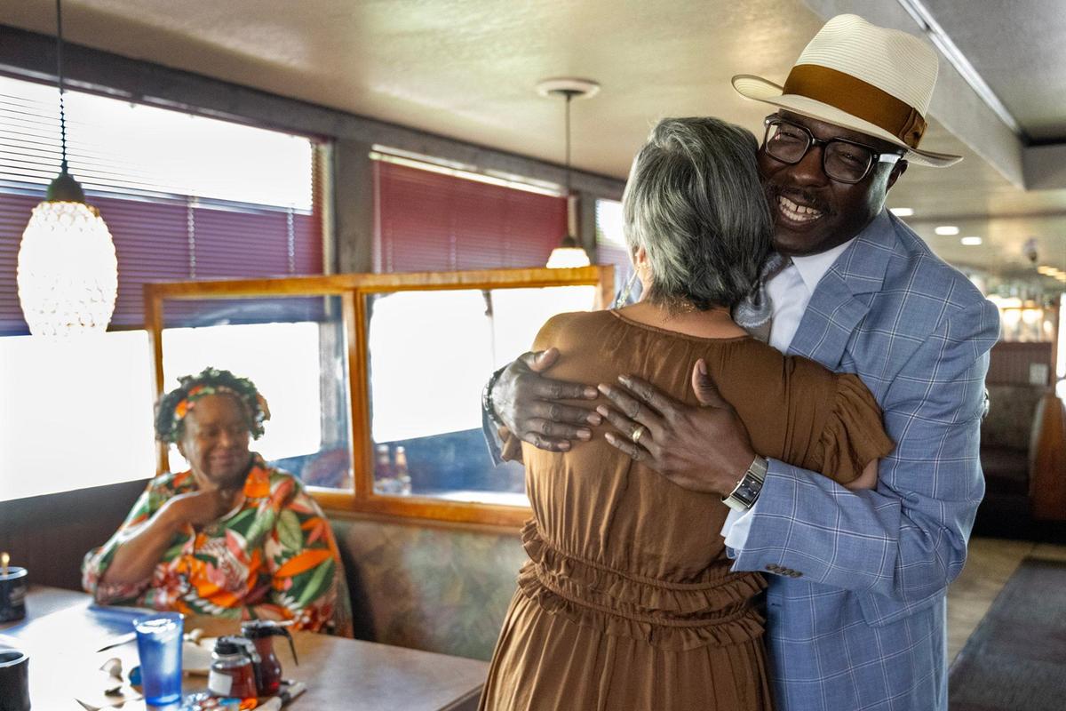 Candace Cheatem, left, looks on as Bob Kendrick gets a hug from Deidre Anderson-Barbee when he his arrive at Niecie’s, a regular breakfast spot for him.