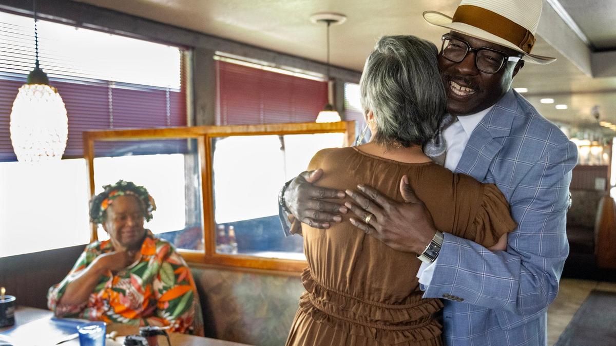 Candace Cheatem, left, looks on as Bob Kendrick gets a hug from Deidre Anderson-Barbee when he his arrive at Niecie’s, a regular breakfast spot for him.