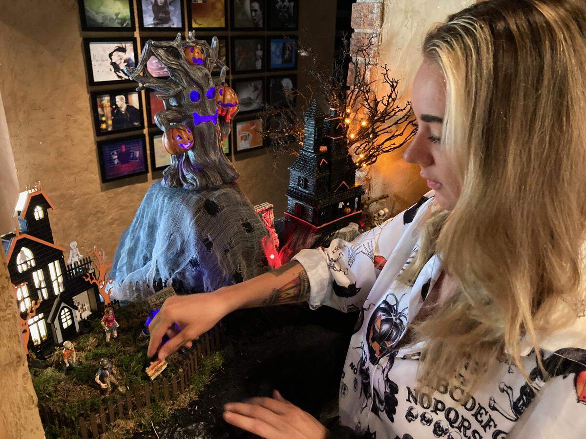 Lucky Perez, a Cafe Trio server now for seven years, decorates the restaurant’s Halloween village in 2023.