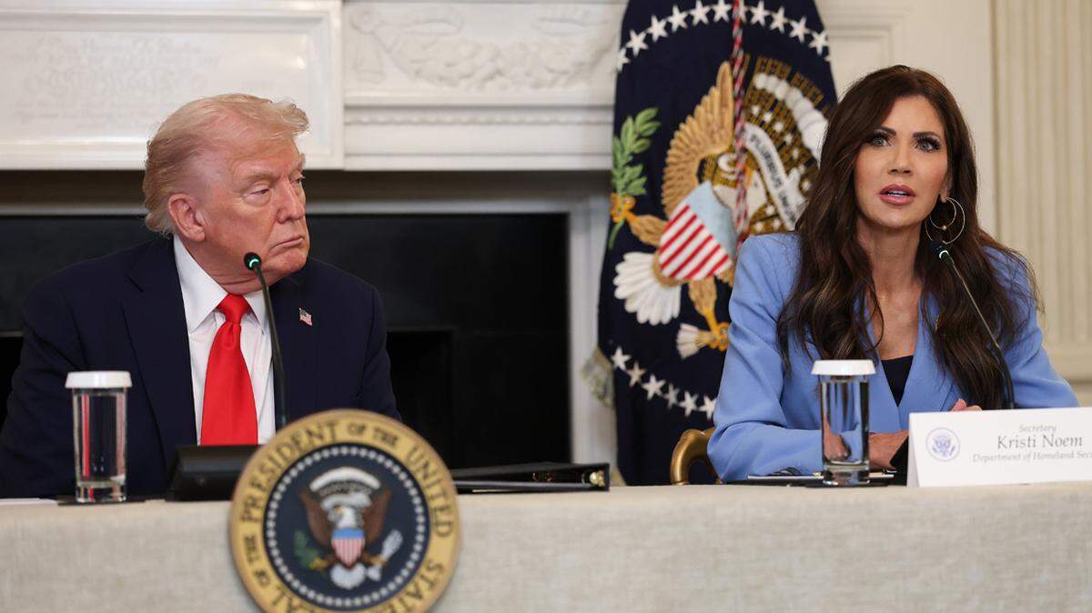 WASHINGTON, DC - OCTOBER 08: U.S. Secretary of Homeland Security Kristi Noem (R) speaks as U.S. President Donald Trump listens during a roundtable discussion in the State Dining Room of the White House on October 08, 2025 in Washington, DC. Trump’s administration held the roundtable to discuss the anti-fascist Antifa movement after signing an executive order designating it as a “domestic terrorist organization”. (Photo by Anna Moneymaker/Getty Images)