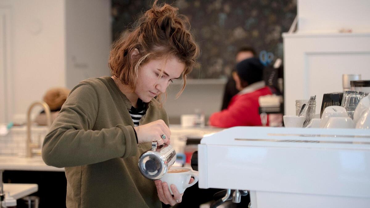 Lydia Gough, assistant manager at Post Coffee Company, prepares a latte on Tuesday, Nov. 15, 2022, in Kansas City.