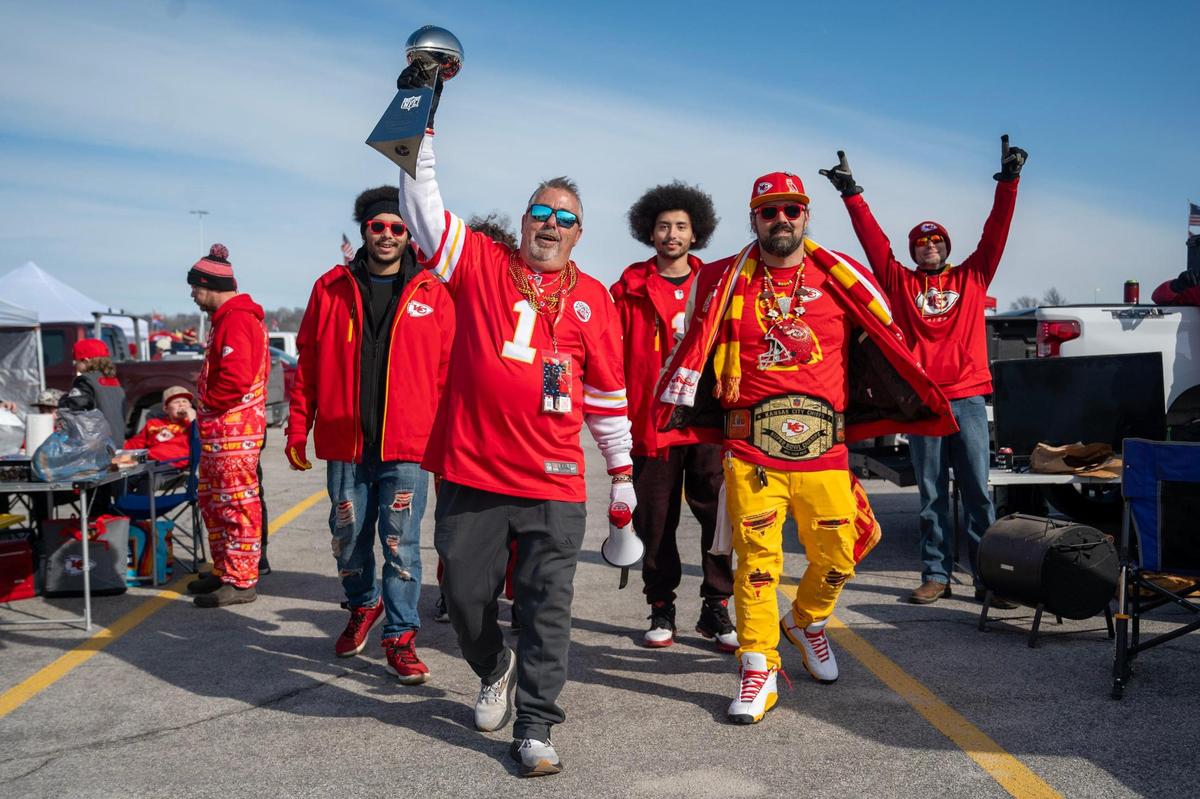 Die-hard Chiefs fans Terry Gilmore, left, of Independence, his son, Michael Lutman, right, of Kansas City, and grandsons Dante and Damian Spears, left and rear, both of Kansas City, proudly paraded through the parking lot with a replica of the Lombardi Trophy from Super Bowl LVII ahead of the Chiefs’ AFC Championship Game against the Buffalo Bills on Sunday, Jan. 26, 2025, at GEHA Field at Arrowhead Stadium.