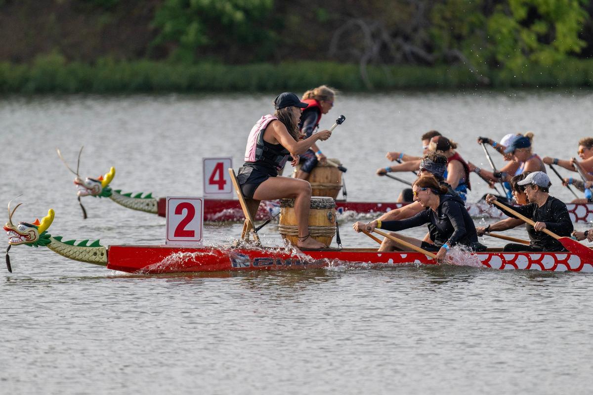 Crew members from SLAP Dragons KC (4) and Hump Day 5K Rapid Racers (2) compete for first place in a qualifying race during the KC Dragon Boat Festival on Saturday, Sept. 28, 2024, at Shawnee Mission Park.