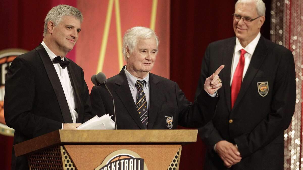 Tex Winter, center, gestures as his son, Chris Winter, left, delivers the address for his father at his Basketball Hall of Fame enshrinement ceremony in Springfield, Mass., Friday, Aug. 12, 2011. At right is Phil Jackson. (AP Photo/Stephan Savoia) ORG XMIT: MASS120