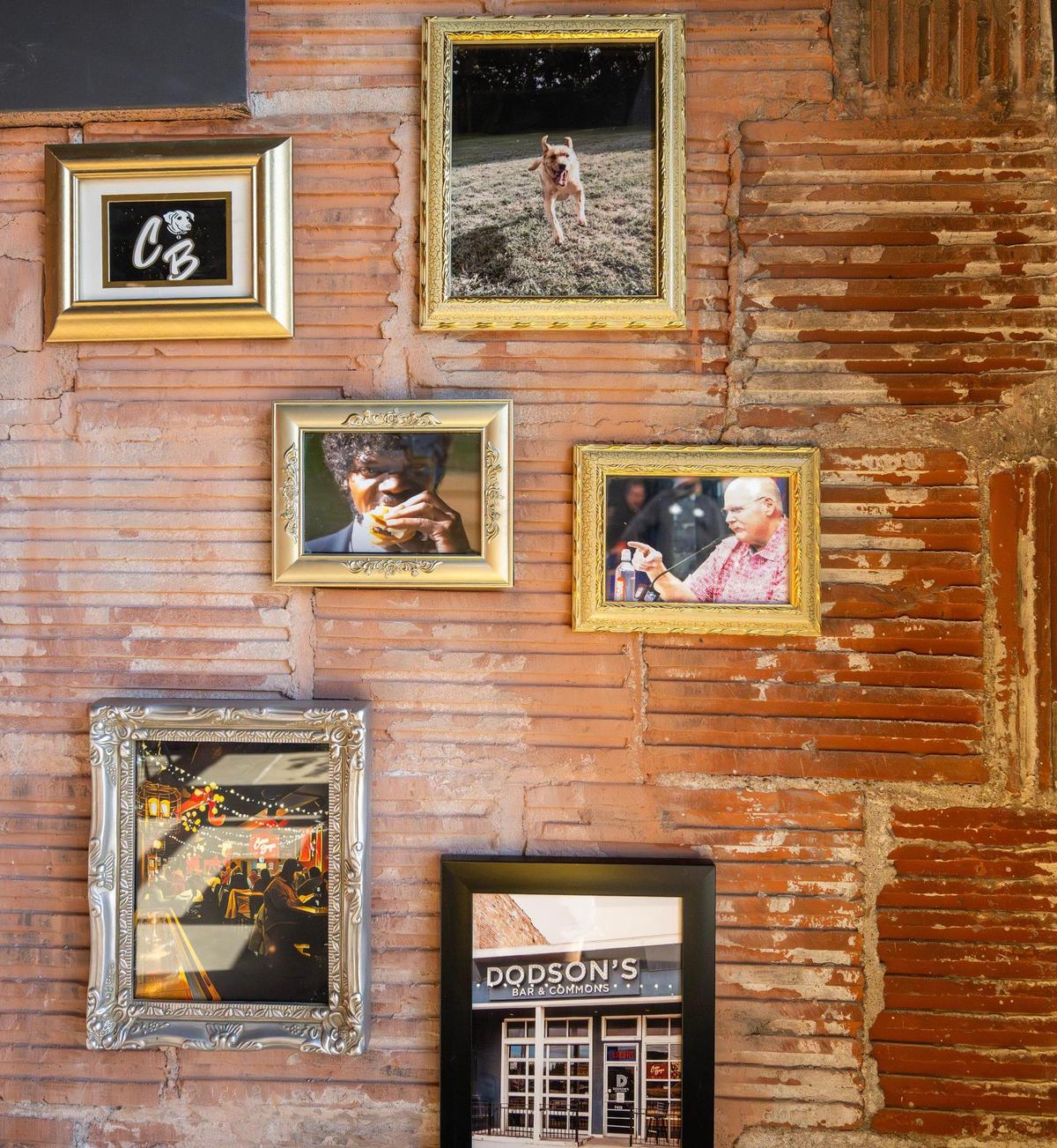 A wall of framed photos inside Cosmo Burger includes Samuel L. Jackson eating a burger in the movie “Pulp Fiction” and well-known burger fan (and Chiefs head coach) Andy Reid.