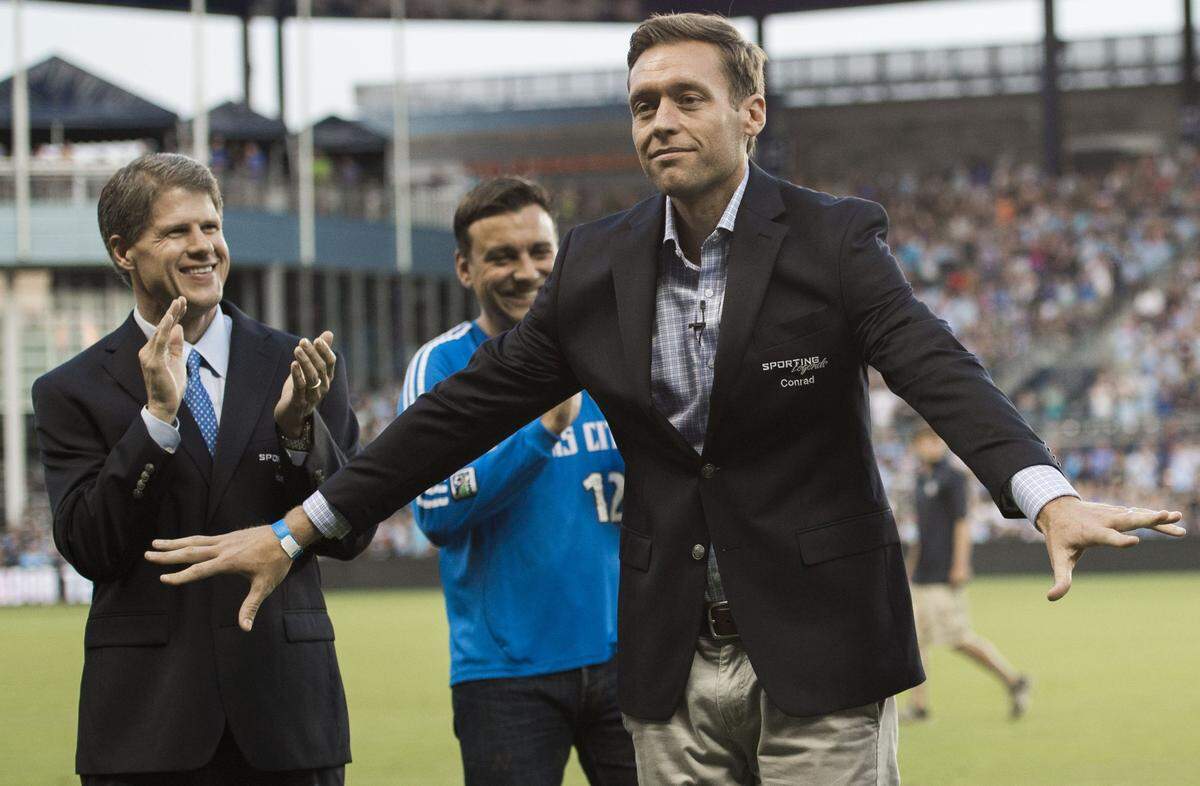 Representing his late father Lamar Hunt, Chiefs chairman and CEO Clark Hunt (left), joined Sporting Kansas City’s Rob Heineman in applauding Jimmy Conrad as Conrad and Peter Vermes were inducted as Sporting Legends during a 2014 ceremony at the soccer stadium in Kansas City, Kansas.