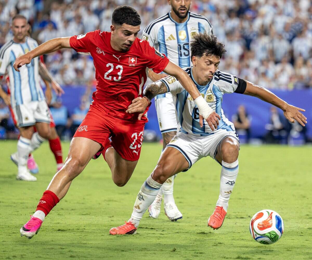 Switzerland forward Zeki Amdouni (23) and Argentina defender Lisandro Martínez (6) battle for possession of the ball during the second half of the FIFA World Cup quarterfinal at Kansas City (Arrowhead) Stadium on Saturday, July 11, 2026.