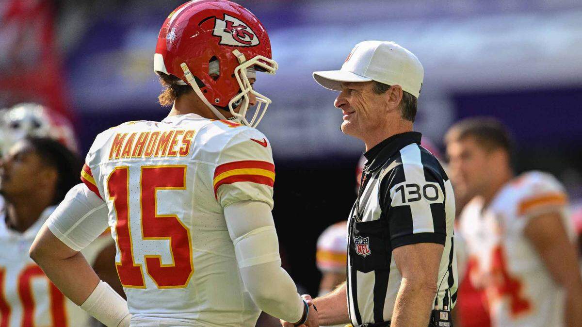 Kansas City Chiefs quarterback Patrick Mahomes (15) shakes hands with referee Land Clark (130) before the game against the Minnesota Vikings at U.S. Bank Stadium.
