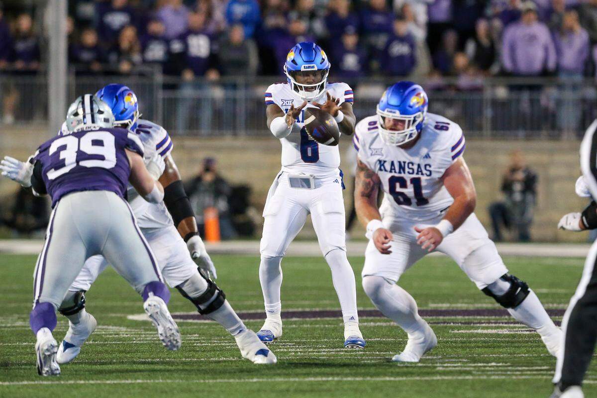 Kansas Jayhawks quarterback Jalon Daniels takes a snap from center Bryce Foster (No. 61) during a game against Kansas State at Bill Snyder Family Football Stadium in Manhattan on Oct. 26, 2024.