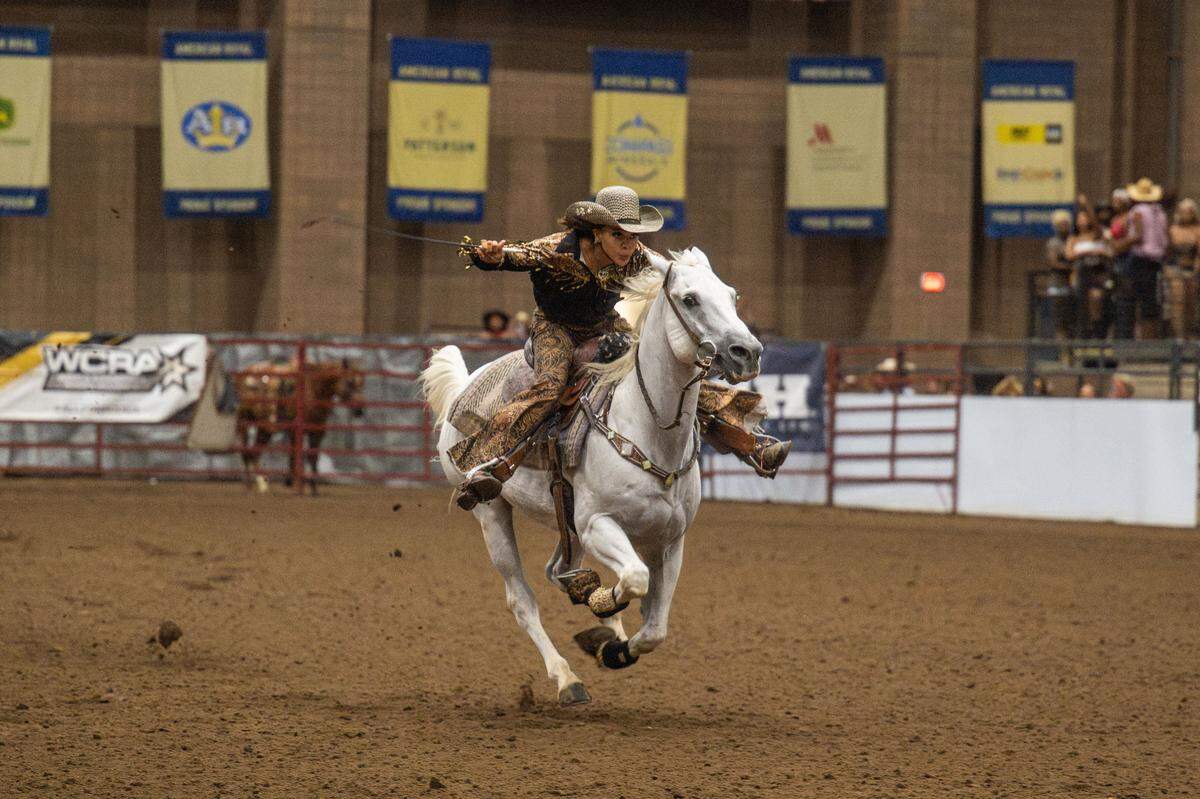 Michaela Mitchell rides with speed and determination at the Black Rodeo USA show, inside the American Royal in Kansas City on Saturday. Mitchell competed in the Ladies’ barrel racing competition.