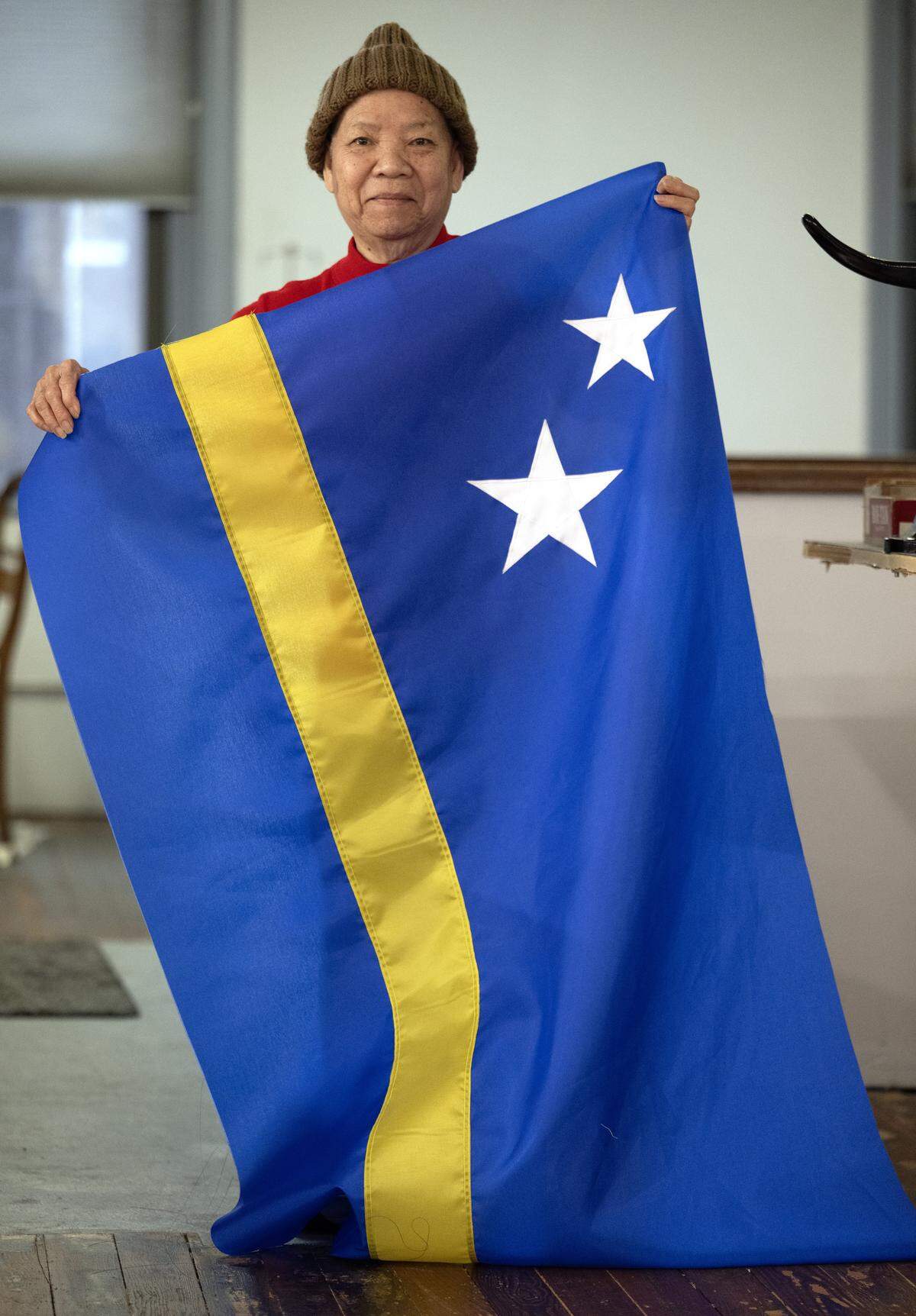 Seamstress Phuong-Thu Nguyen, 78, a native of Vietnam, has been sewing flags at All Nations Flag Co. for over 40 years, displays an almost-finished flag of Curaçao on Thursday, Jan. 8, 2026, in Kansas City. Curacao will be one of seven nations participating in the FIFA World Cup this summer in Kansas City.