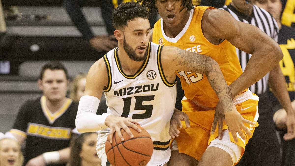 Missouri’s Jordan Geist, left, dribbles past Tennessee’s Yves Pons, right, during the first half Tuesday in Columbia, Mo.