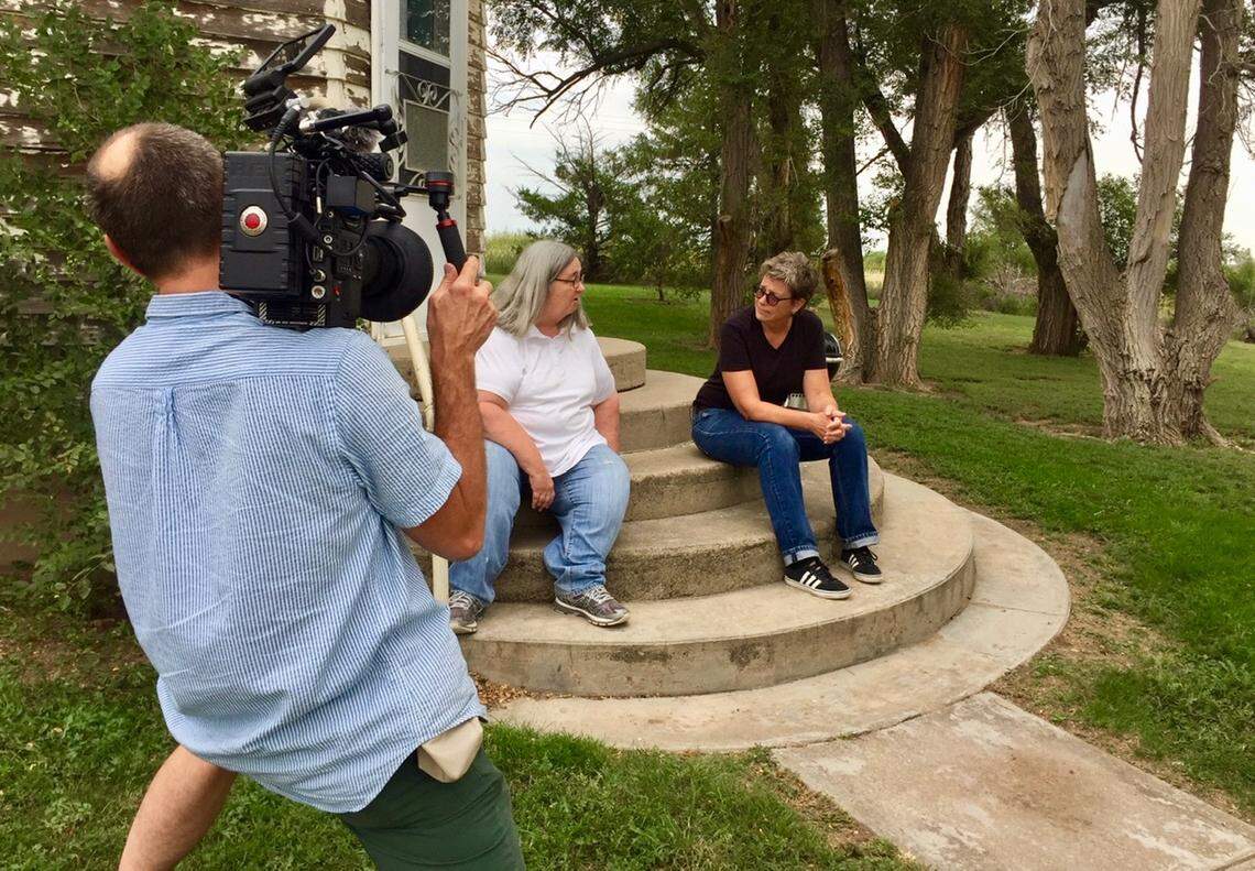 Eric Smith, director of photographer for the “No Place Like Home” film, records a visit author C.J. Janovy, right, makes to Sandra Stenzel on her farm in WaKeeney, Kansas.
