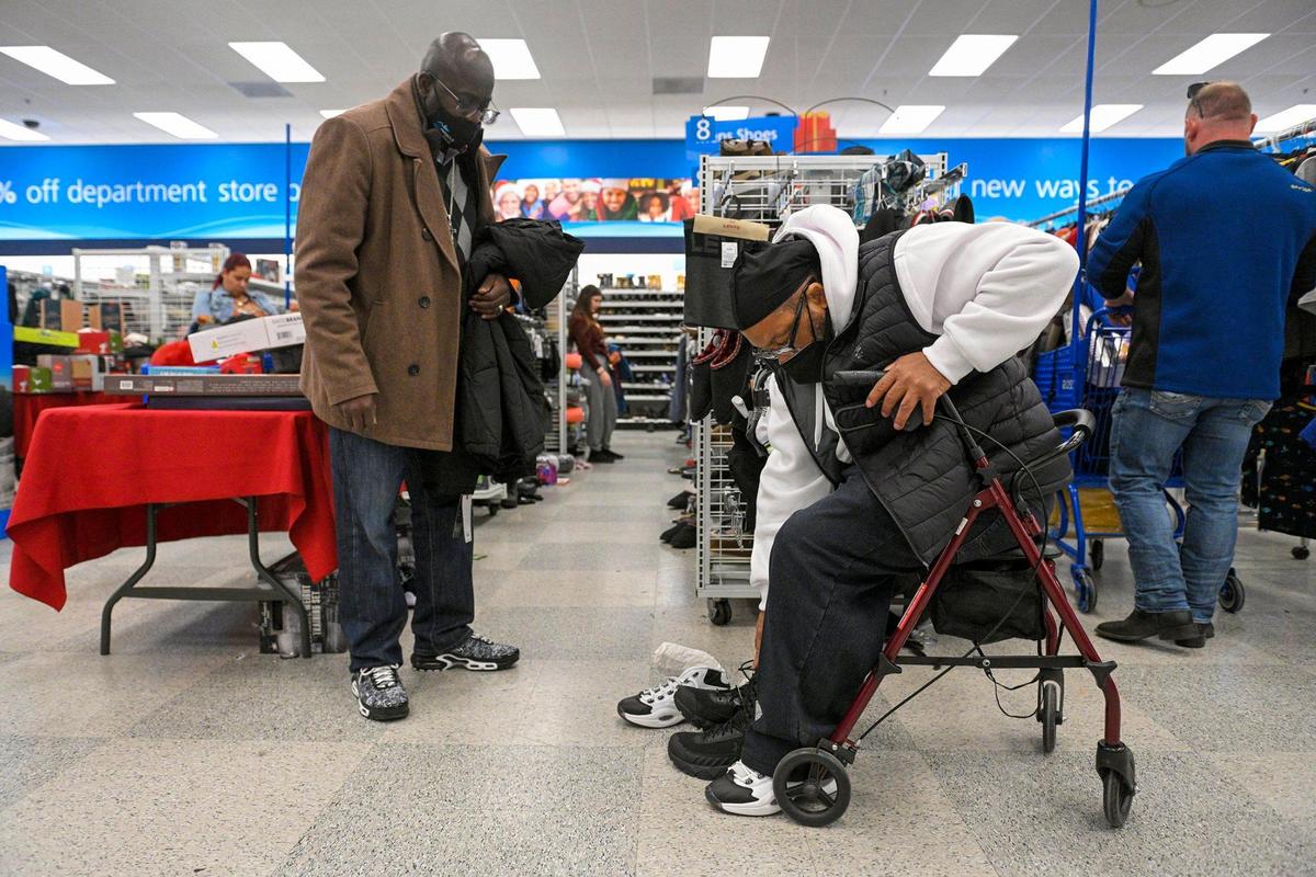 The Rev. Darryl Burton, left, helped Kevin Strickland find shoes while shopping for winter clothes Tuesday, Dec. 21, 2021. Burton, himself an exoneree who spent 24 years in prison, co-founded Miracle of Innocence with fellow exoneree Lamonte McIntyre. The organization helps provide care for the wrongly convicted after they are freed from incarceration.