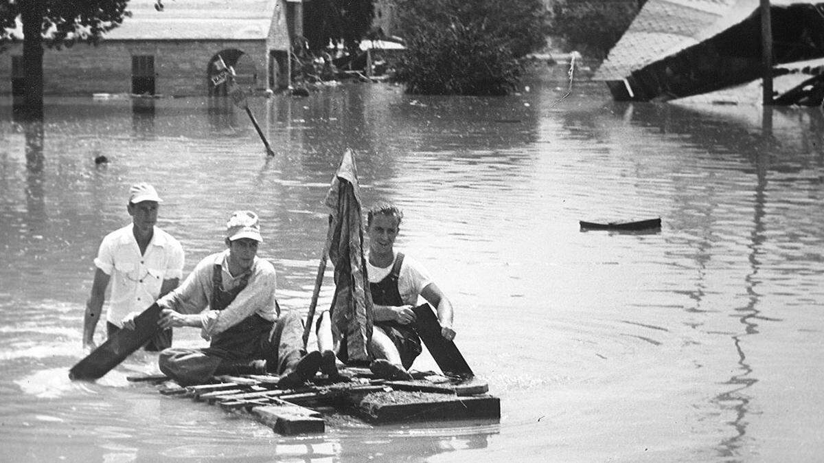 Men paddle a raft near Mill Street Bridge in Armourdale.