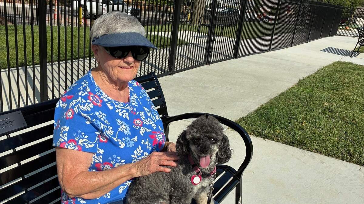 Bonnie Berkihiser sits with her dog, Fonzie, in the dog park at John Knox Village in Lee’s Summit. Fonzie is an 8-year-old poodle.