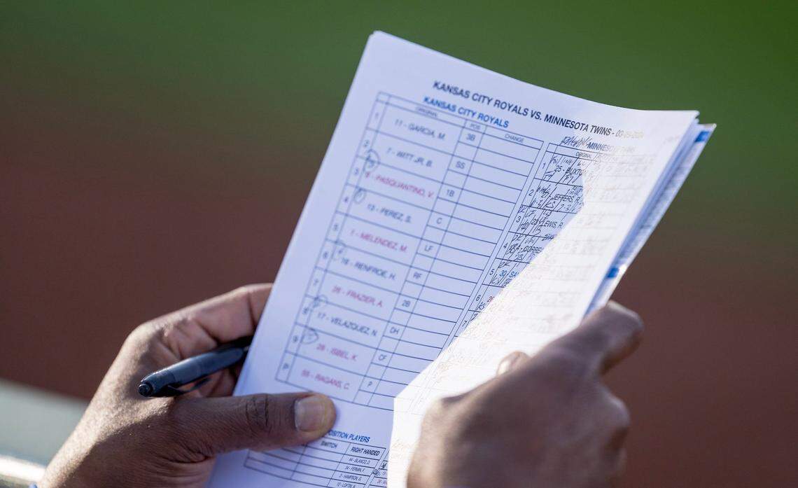 Kansas City Royals first base coach Damon Hollins checks notes on Minnesota Twins hitters during the Royals’ home opener Thursday at Kauffman Stadium.