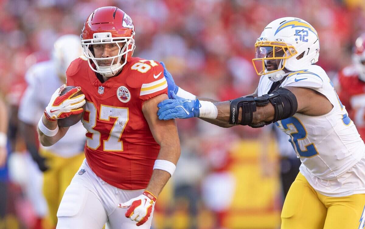 Kansas City Chiefs tight end Travis Kelce (87) tries to break away from Los Angeles Chargers linebacker Khalil Mack (52) during the first half on Sunday at Arrowhead Stadium.